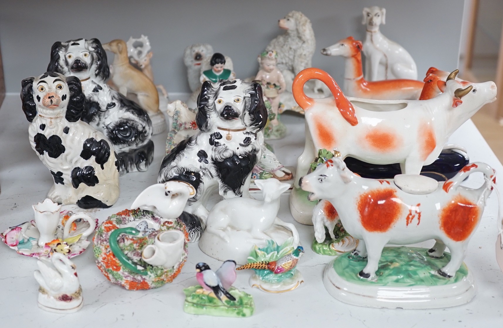 A quantity of Victorian Staffordshire animal figures, two pearlware putti and a Derby figure of a cherub, tallest 14.5 cm